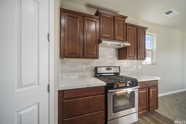 7117 Mustengo Dr, Reno, NV 89506 - kitchen featuring gas stove, under cabinet range hood, backsplash, baseboards, and dark wood-type flooring