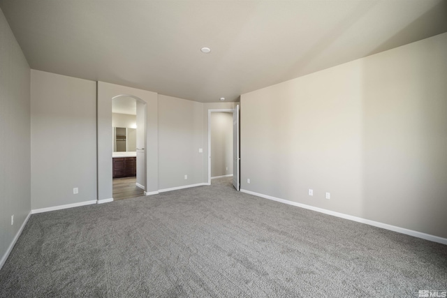 7117 Mustengo Dr, Reno, NV 89506 - unfurnished bedroom featuring arched walkways, carpet floors, baseboards, and ensuite bath