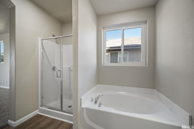 7117 Mustengo Dr, Reno, NV 89506 - full bathroom with a bath, a shower stall, wood finished floors, and baseboards