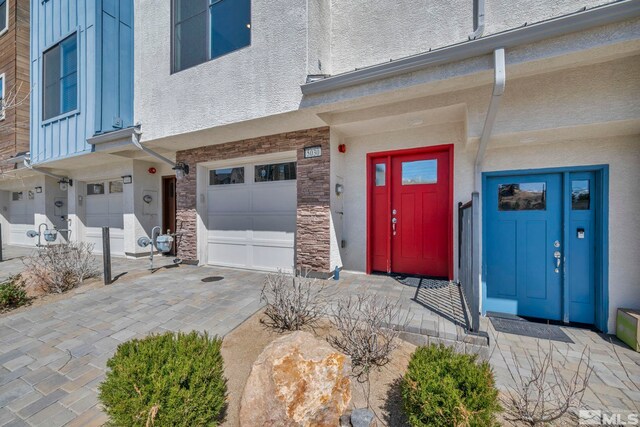 5030 Ronald Stephen Cir, Reno, NV 89503 - property entrance featuring a garage, stone siding, and board and batten siding