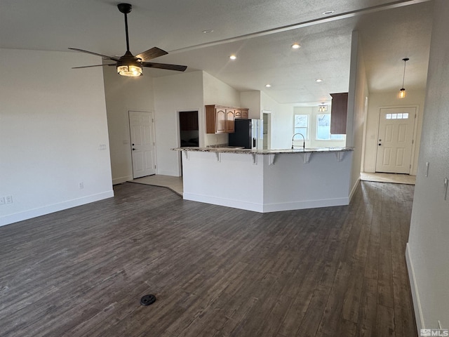794 Megan Way, Fallon, NV 89406 - unfurnished living room with dark wood-style flooring, baseboards, vaulted ceiling, ceiling fan, and recessed lighting