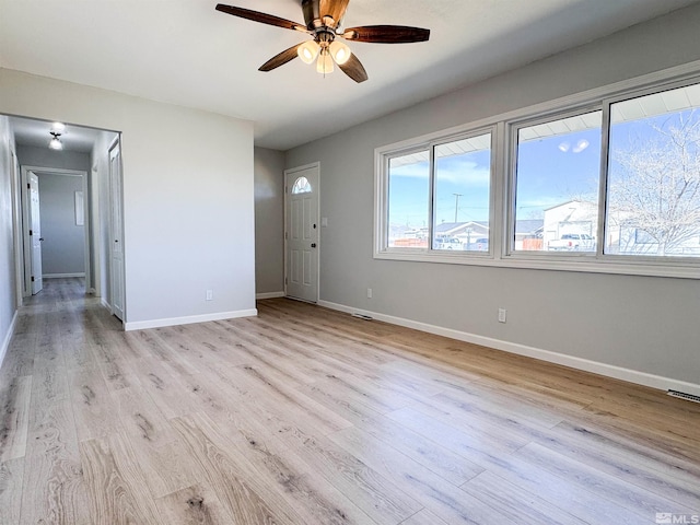 675 L St, Hawthorne, NV 89415 - unfurnished living room with a ceiling fan, baseboards, and light wood-type flooring