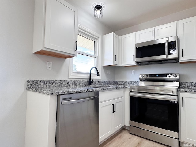 675 L St, Hawthorne, NV 89415 - kitchen featuring appliances with stainless steel finishes, a sink, light stone countertops, and white cabinetry