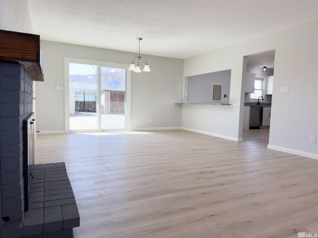 675 L St, Hawthorne, NV 89415 - unfurnished living room with a chandelier, light wood finished floors, healthy amount of natural light, and baseboards