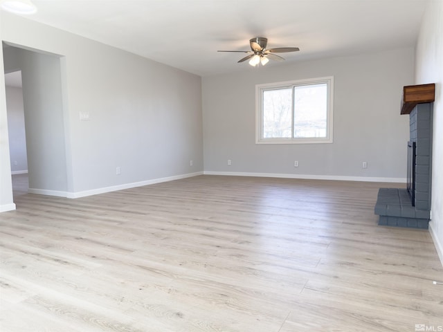 675 L St, Hawthorne, NV 89415 - unfurnished living room with a ceiling fan, light wood finished floors, baseboards, and a brick fireplace