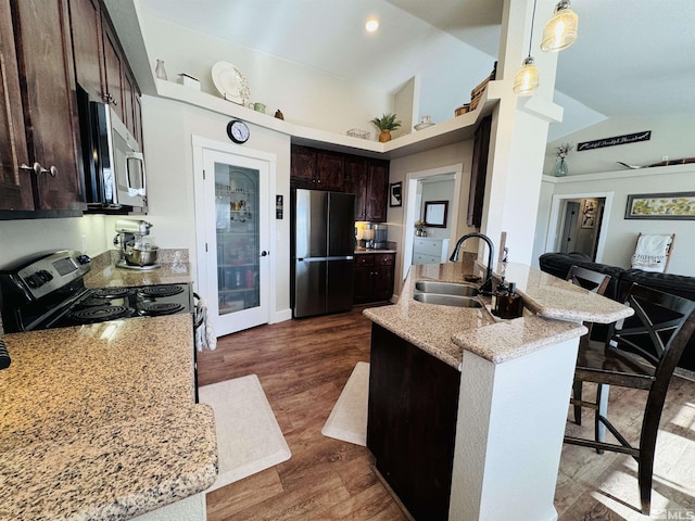 629 Ross St, Winnemucca, NV 89445 - kitchen with stainless steel appliances, a sink, dark brown cabinetry, a breakfast bar, and decorative light fixtures