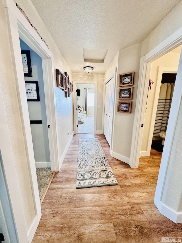 629 Ross St, Winnemucca, NV 89445 - hall featuring a textured ceiling, light wood finished floors, and baseboards