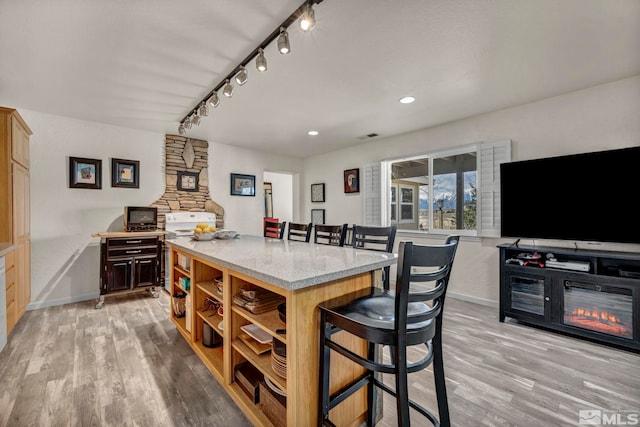 1568 Barker Ct, Gardnerville, NV 89410 - kitchen featuring open shelves, a kitchen breakfast bar, track lighting, baseboards, and light wood-type flooring