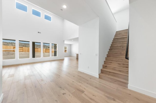 2983 Murrelet Way Unit Cinmon 169, Sparks, NV 89441 - unfurnished living room with healthy amount of natural light, stairway, a high ceiling, light wood finished floors, and recessed lighting