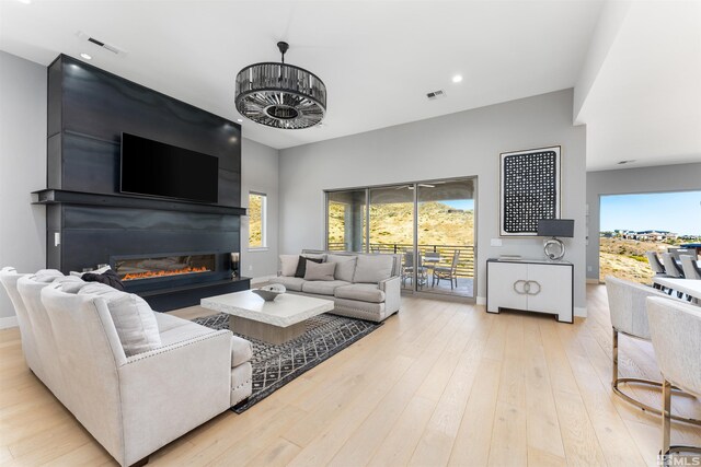 8956 Suncreek Trl, Reno, NV 89523 - living area featuring a glass covered fireplace, light wood-style floors, and recessed lighting