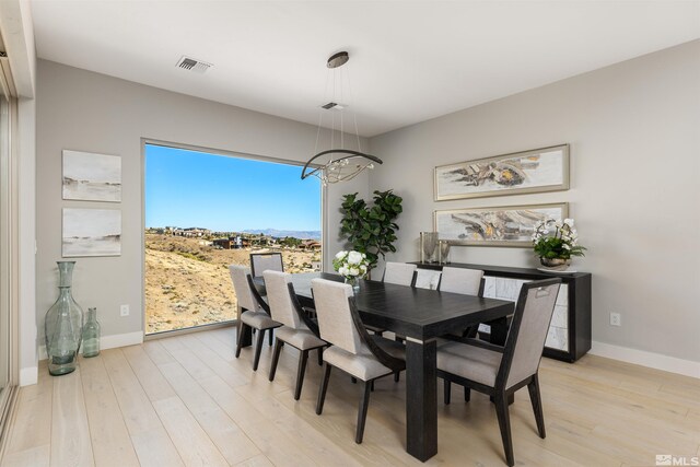 8956 Suncreek Trl, Reno, NV 89523 - dining space with light wood-style floors, a chandelier, and a mountain view
