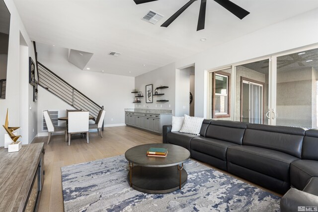 8956 Suncreek Trl, Reno, NV 89523 - living area featuring light wood finished floors, ceiling fan, stairway, and bar