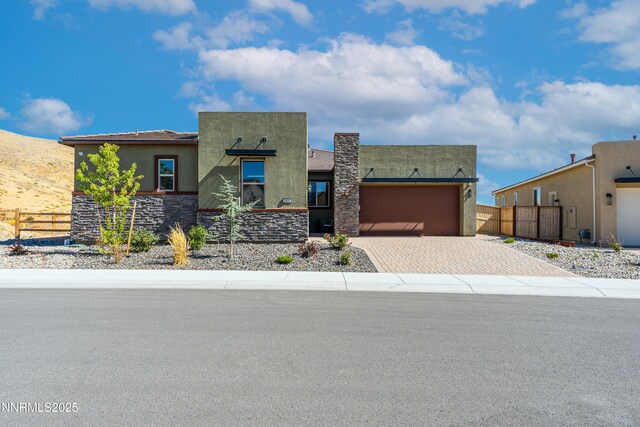8956 Suncreek Trl, Reno, NV 89523 - view of front of house with stucco siding, decorative driveway, a garage, and stone siding