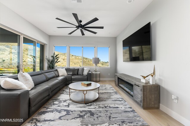 8956 Suncreek Trl, Reno, NV 89523 - living room with a ceiling fan, light wood-style flooring, and a glass covered fireplace