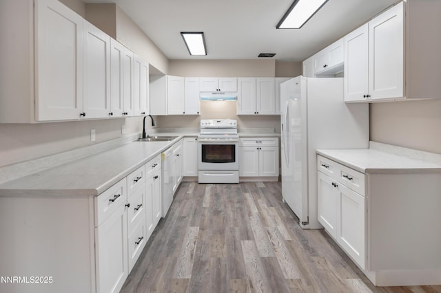 1600 Duke Way, Reno, NV 89502 - kitchen featuring white appliances, a sink, under cabinet range hood, white cabinets, and light wood-style flooring