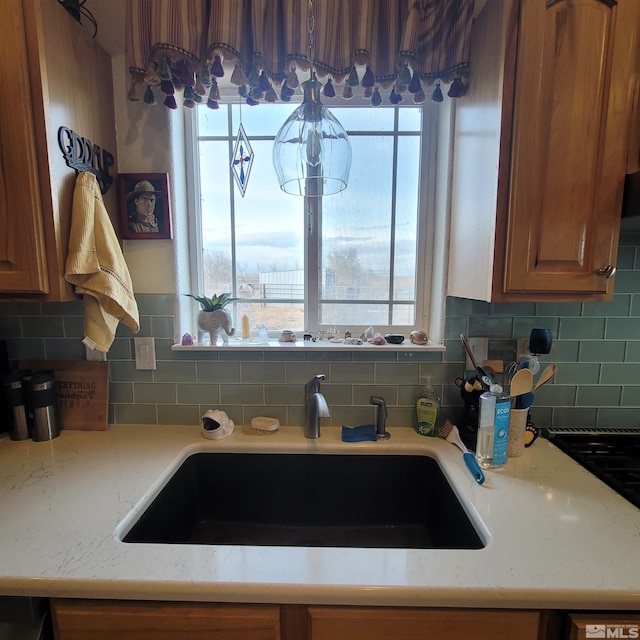 3860 Edwards Ln, Fallon, NV 89406 - kitchen featuring plenty of natural light, backsplash, brown cabinetry, and light stone countertops