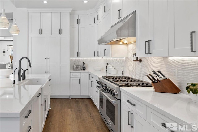 20765 Parc Foret Dr, Reno, NV 89511 - kitchen featuring under cabinet range hood, double oven range, dark wood-style flooring, white cabinetry, and decorative backsplash