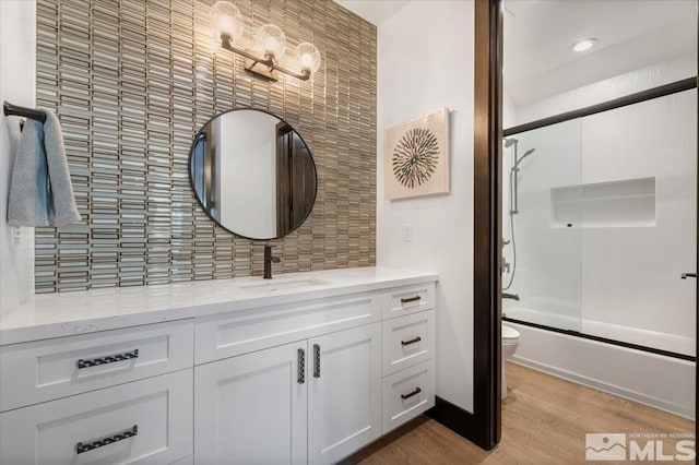 20765 Parc Foret Dr, Reno, NV 89511 - bathroom with wood finished floors, backsplash, toilet, vanity, and combined bath / shower with glass door