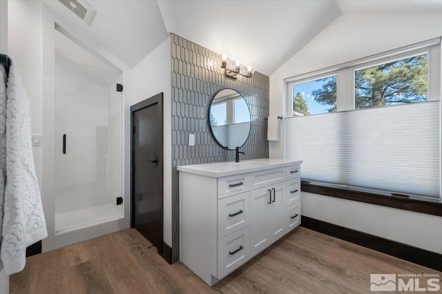20765 Parc Foret Dr, Reno, NV 89511 - bathroom with vaulted ceiling, wood finished floors, a chandelier, vanity, and a shower stall