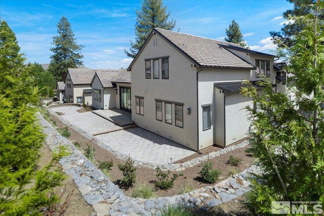 20765 Parc Foret Dr, Reno, NV 89511 - back of property featuring stucco siding, a patio, and a standing seam roof