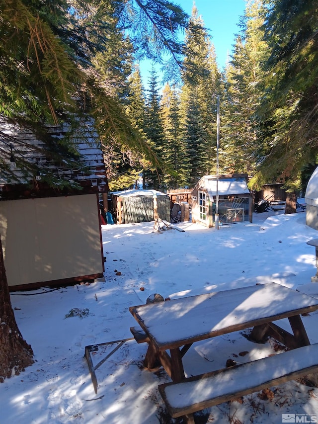 1589 Cree St, South Lake Tahoe, CA 96150 - snow covered deck featuring an outdoor structure and a storage unit