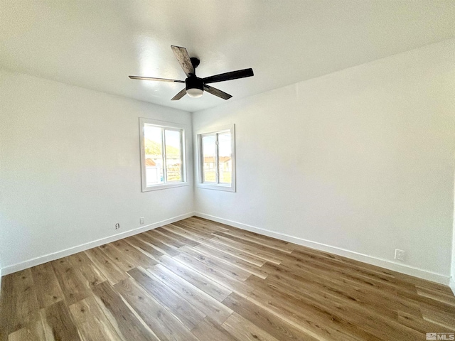 unfurnished room with wood finished floors, a ceiling fan, and baseboards