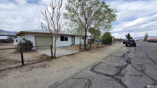 309 M St, Hawthorne, NV 89415 - view of front facade with an attached garage, fence, driveway, and stucco siding