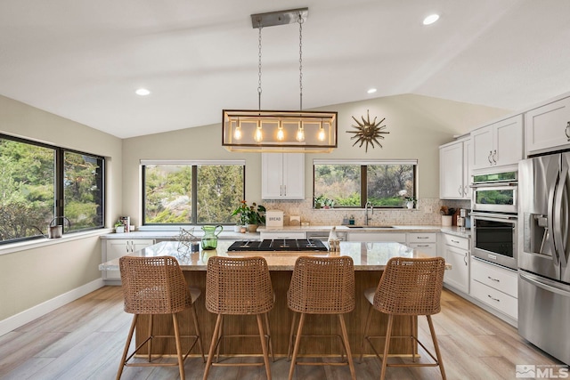4400 Bridle Way, Reno, NV 89519 - kitchen with stainless steel appliances, a sink, vaulted ceiling, backsplash, and white cabinets
