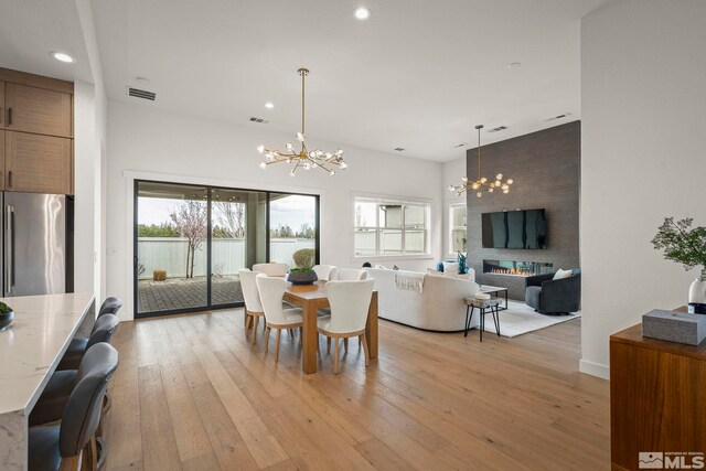 605 Braided Rope Dr, Reno, NV 89511 - dining room with a chandelier, light wood-type flooring, recessed lighting, and a fireplace