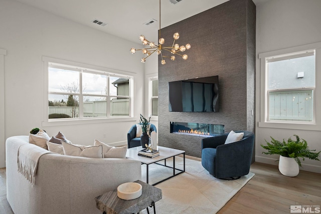 605 Braided Rope Dr, Reno, NV 89511 - living area with wood finished floors, a chandelier, a glass covered fireplace, and baseboards