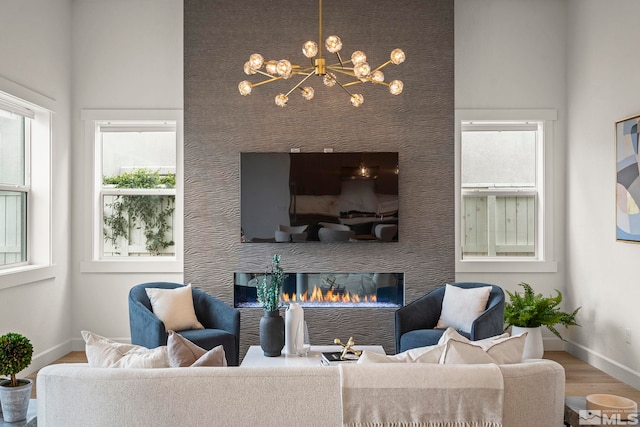 605 Braided Rope Dr, Reno, NV 89511 - living area with a chandelier, wood finished floors, baseboards, and a glass covered fireplace