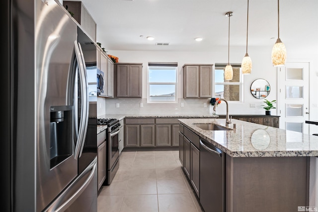 3617 Pulsar Ln Unit 2, Carson City, NV 89705 - kitchen with stainless steel appliances, a sink, light tile patterned floors, an island with sink, and decorative backsplash