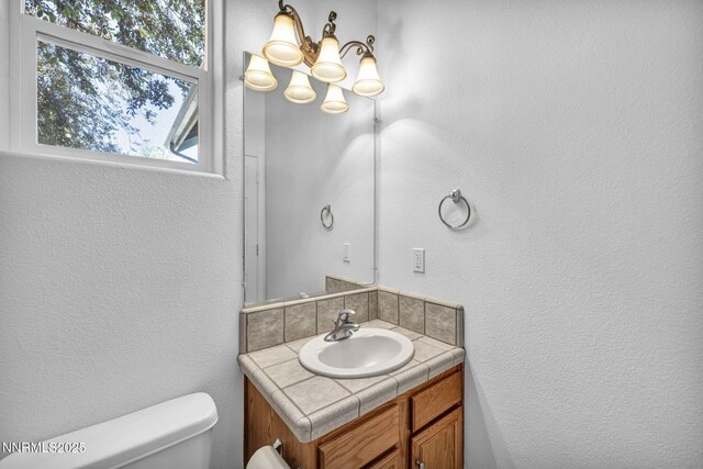 1655 Chiquita Cir, Minden, NV 89423 - half bath with vanity, toilet, a textured wall, and a chandelier