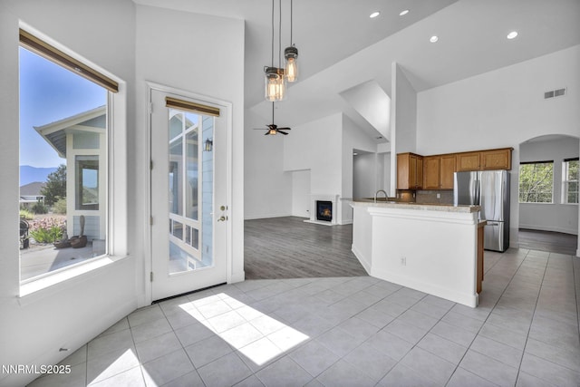 1655 Chiquita Cir, Minden, NV 89423 - kitchen featuring freestanding refrigerator, light tile patterned flooring, brown cabinets, ceiling fan, and decorative light fixtures