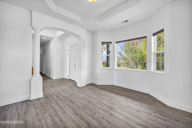1655 Chiquita Cir, Minden, NV 89423 - empty room featuring a raised ceiling, ornate columns, wood finished floors, arched walkways, and ornamental molding
