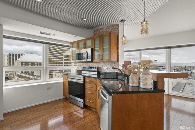 255 N Sierra St Unit 1011, Reno, NV 89501 - kitchen with stainless steel appliances, a sink, brown cabinets, dark wood-type flooring, and glass insert cabinets