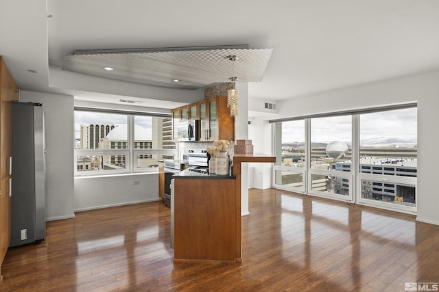 255 N Sierra St Unit 1011, Reno, NV 89501 - kitchen featuring stainless steel appliances, dark wood-style floors, dark countertops, glass insert cabinets, and recessed lighting