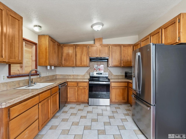 1248 Lindsay Ln, Carson City, NV 89706 - kitchen with appliances with stainless steel finishes, a sink, under cabinet range hood, light countertops, and brown cabinets
