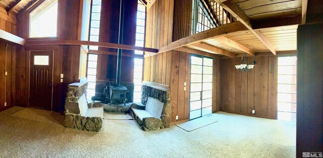 712 Lakeview Dr, Zephyr Cove, NV 89448 - unfurnished living room featuring wooden walls, beam ceiling, carpet, a chandelier, and wooden ceiling