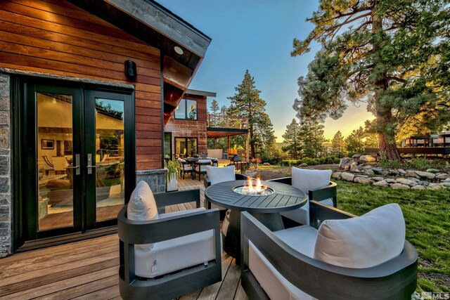 deck with an outdoor fire pit and french doors