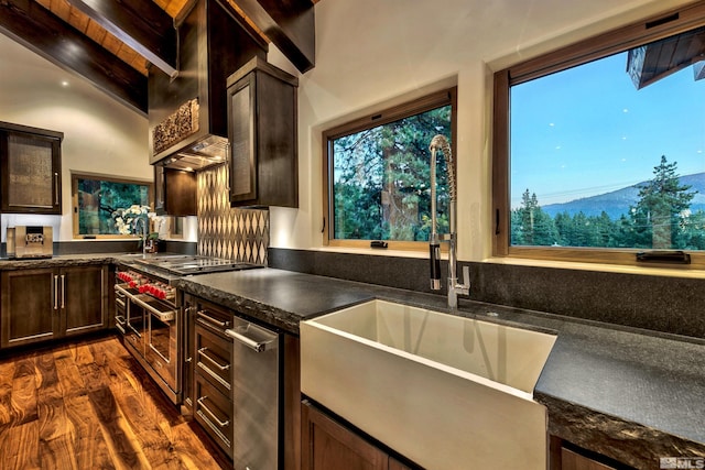 kitchen with range with two ovens, a sink, dark countertops, dark wood-type flooring, and dark brown cabinetry