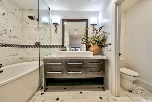 full bath featuring vanity, marble finish floors, a freestanding tub, toilet, and a tile shower