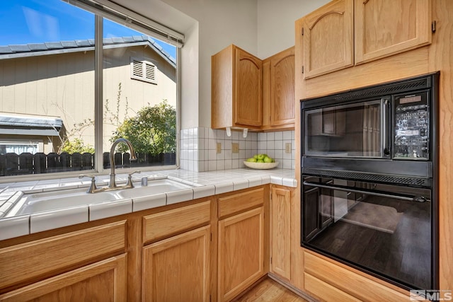 1675 Crestside Ct, Sparks, NV 89436 - kitchen with backsplash, light wood-style flooring, a sink, black microwave, and tile countertops