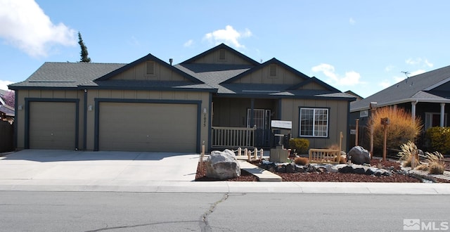 1075 Aster Ln, Fernley, NV 89408 - view of front facade featuring a garage, driveway, board and batten siding, and a shingled roof
