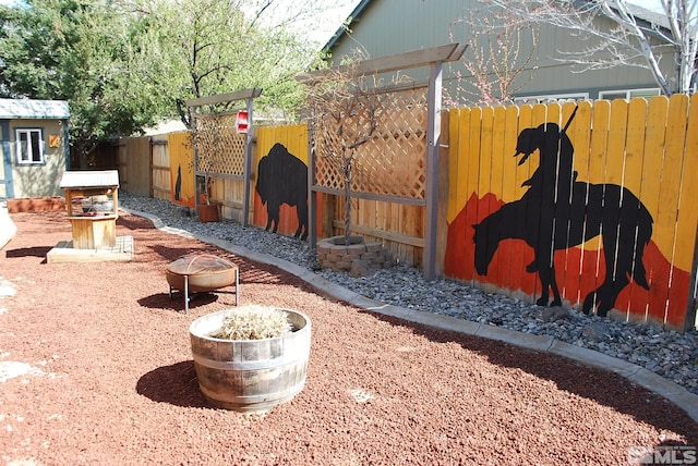 1075 Aster Ln, Fernley, NV 89408 - fenced backyard featuring an outdoor fire pit and an outbuilding