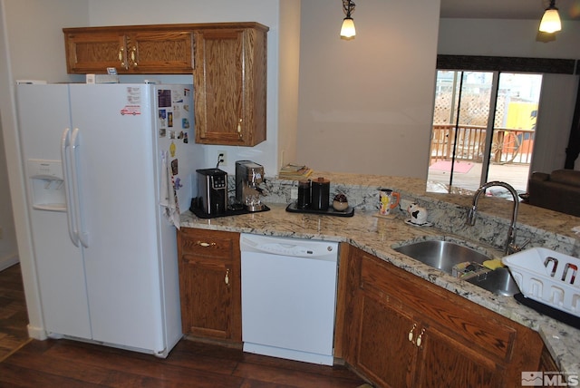 1075 Aster Ln, Fernley, NV 89408 - kitchen with white appliances, brown cabinetry, dark wood-style flooring, light stone counters, and a sink