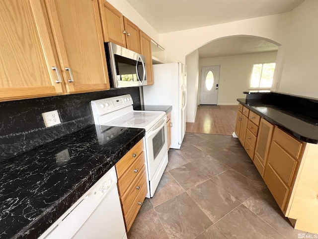 655 Gault Way, Sparks, NV 89431 - kitchen with white appliances, arched walkways, backsplash, dark countertops, and baseboards