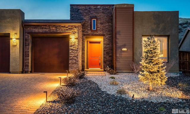 9179 Graycliff Ln, Reno, NV 89523 - view of front of house with stone siding, a garage, driveway, and stucco siding