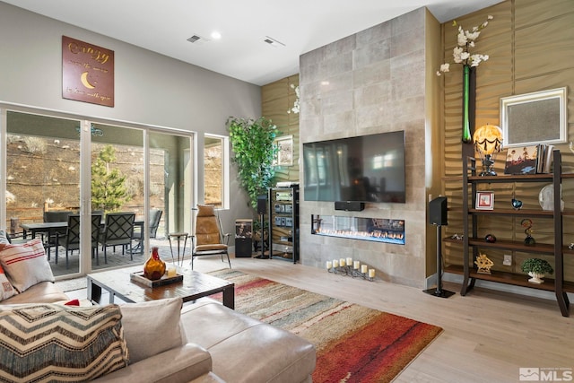 9179 Graycliff Ln, Reno, NV 89523 - living area with a fireplace, wood finished floors, a towering ceiling, recessed lighting, and tile walls