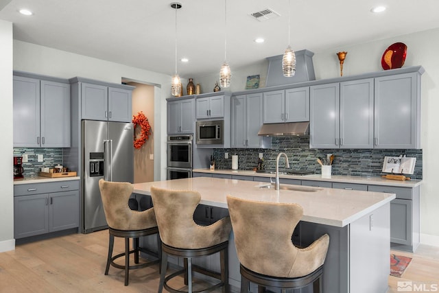 9179 Graycliff Ln, Reno, NV 89523 - kitchen featuring appliances with stainless steel finishes, gray cabinets, under cabinet range hood, tasteful backsplash, and recessed lighting